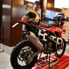 Úsměv továrního jezdce Martina Michka se žlutou přilbou a červeným motocyklem